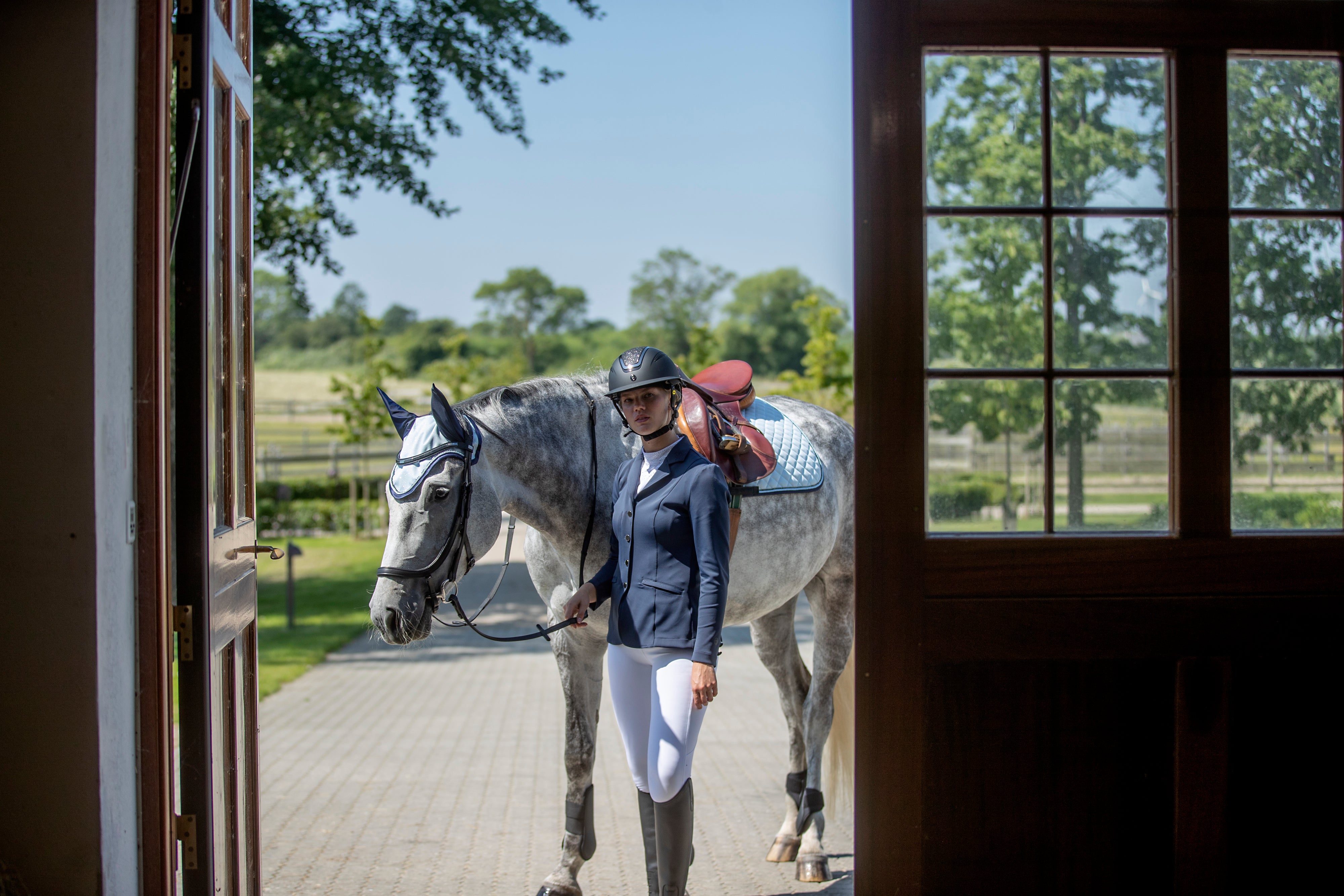 Girl with competition clothes walking with a horse