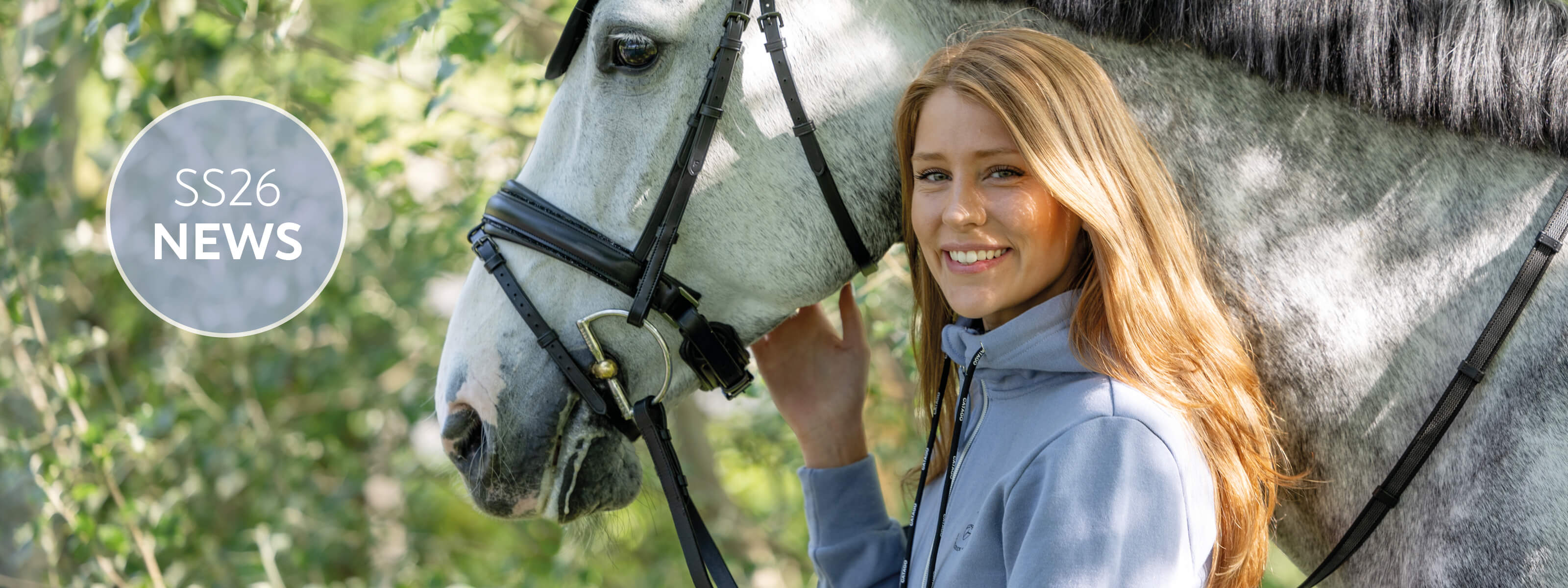 Woman standing next to a horse with a blurred natural background